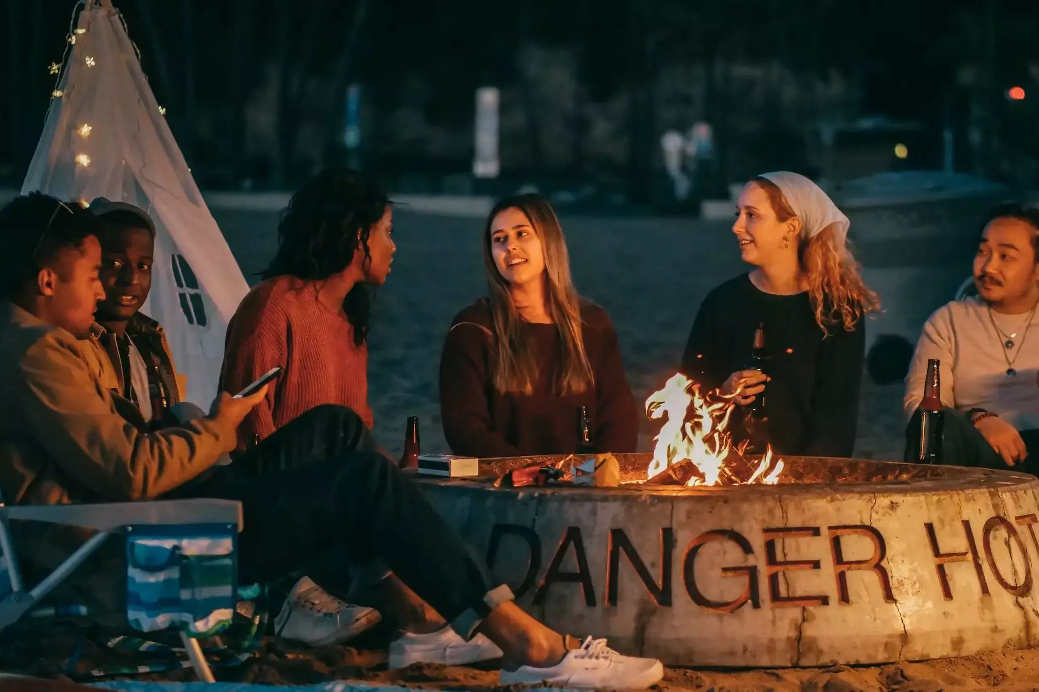 chatting people sitting together around fire pit